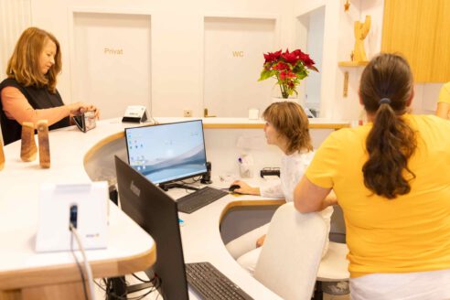 Dr. Prieschl und Team mit einer Patientin am Empfang