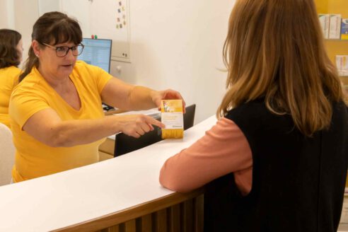 Ordinationsassistentin beim Übergeben eines Medikaments